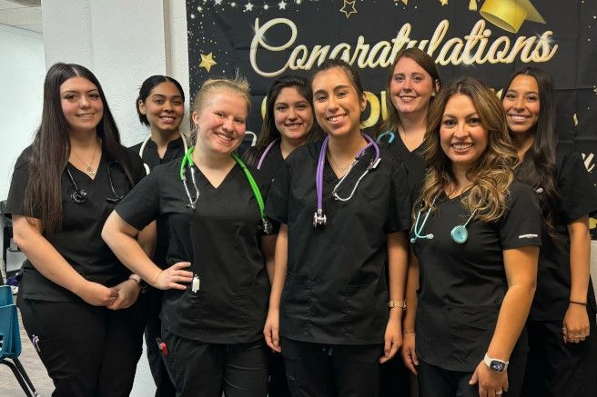 {{ school.name }} graduates posing with congratulatory sign {{ school.name }} graduates posing with congratulatory sign