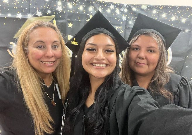 {{ school.name }} graduates posing with congratulatory sign {{ school.name }} graduates posing with congratulatory sign