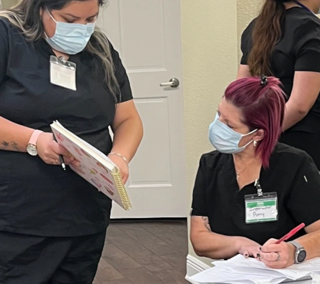 {{ school.name }} instructor reviewing a diagram with a medical assistant student {{ school.name }} instructor reviewing a diagram with a medical assistant student