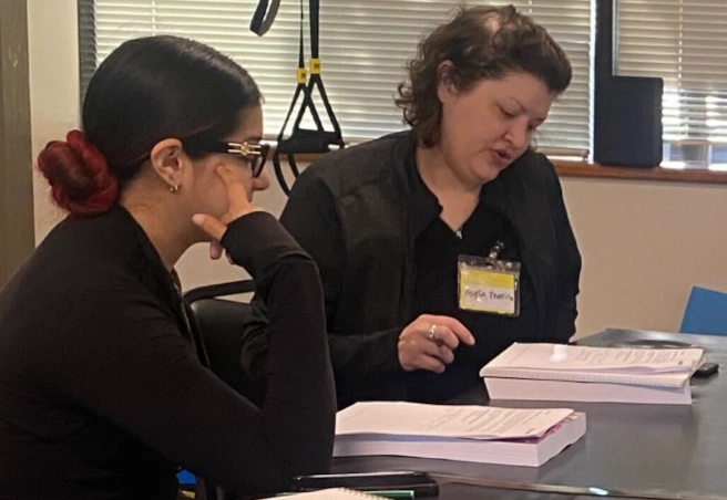 {{ school.name }} instructor reviewing written material with a student {{ school.name }} instructor reviewing written material with a student