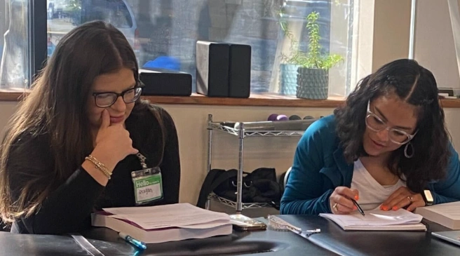 {{ school.name }} students reviewing workbook material {{ school.name }} students reviewing workbook material