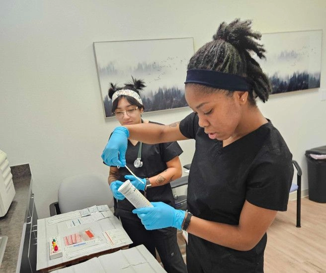 {{ school.name }} students working with medical assisting tools {{ school.name }} students working with medical assisting tools